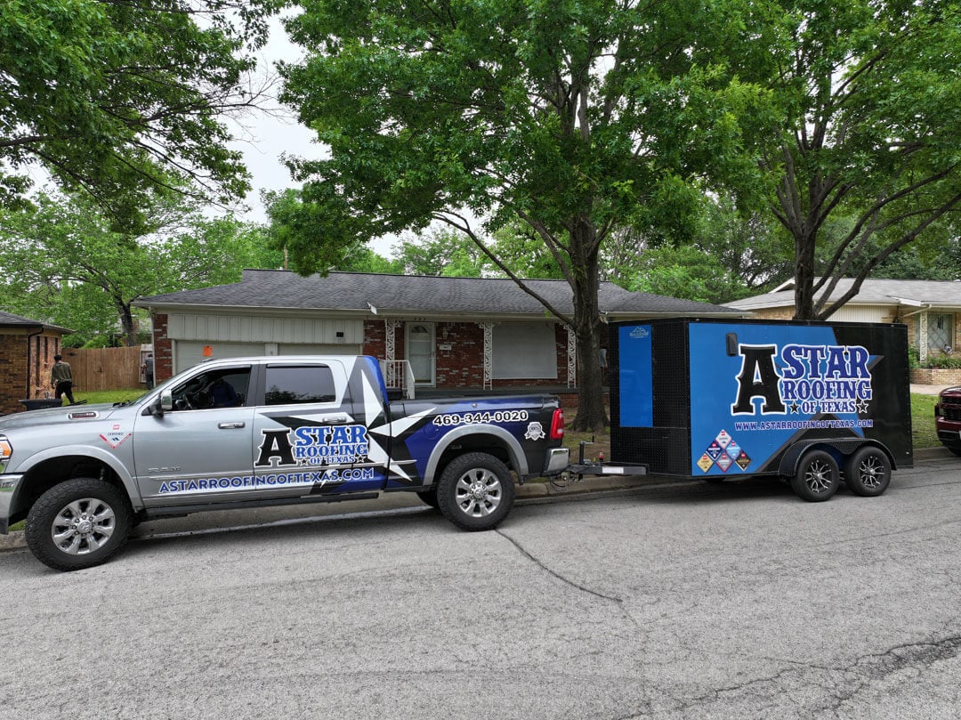 A truck with a trailer in front of a house about to get a new roof installed